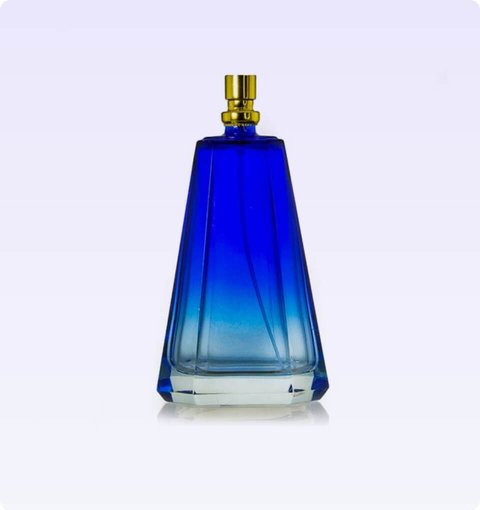 A faceted blue glass fragrance bottle with a gold spray pump