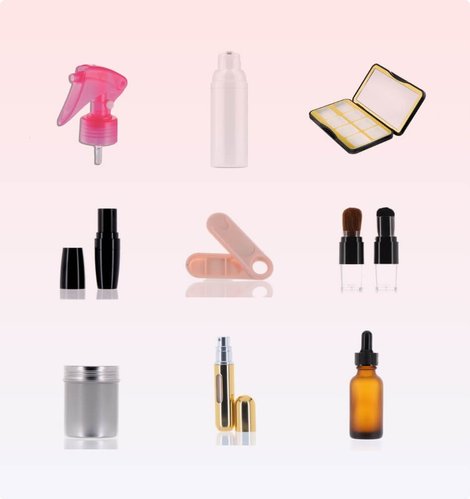 An assortment of color cosmetics packaging — lipstick and gloss tubes, applicators, a compact and a travel atomizer